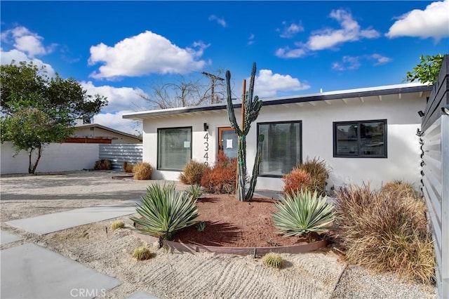 view of front of home with fence and stucco siding