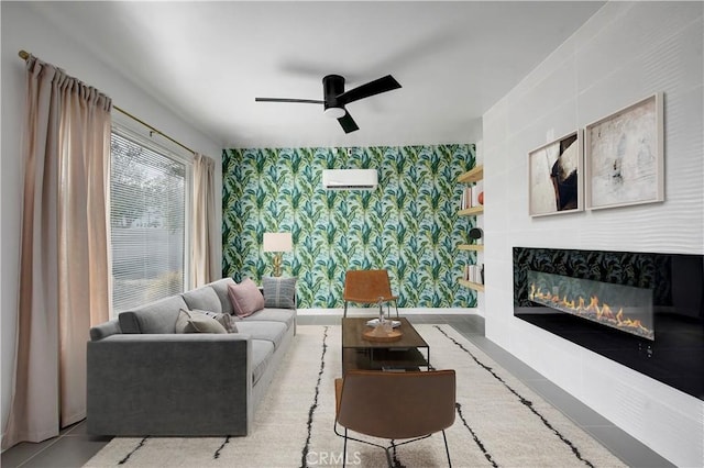 living area with wallpapered walls, baseboards, a ceiling fan, a glass covered fireplace, and tile patterned flooring