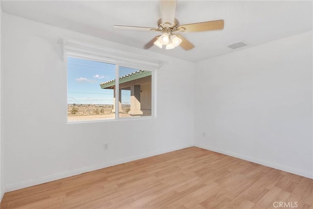 empty room featuring visible vents, ceiling fan, baseboards, and wood finished floors