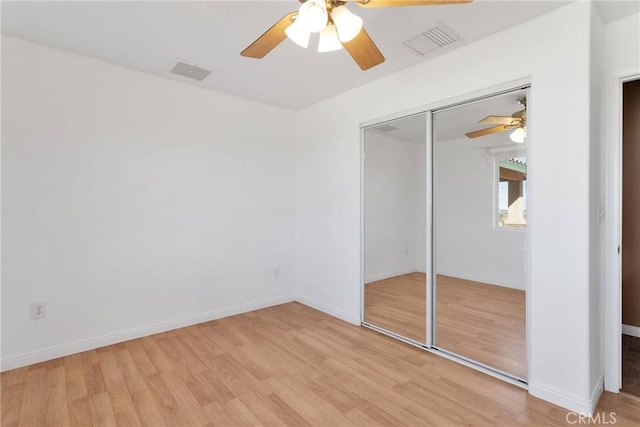 unfurnished bedroom with light wood-style flooring, visible vents, ceiling fan, and a closet