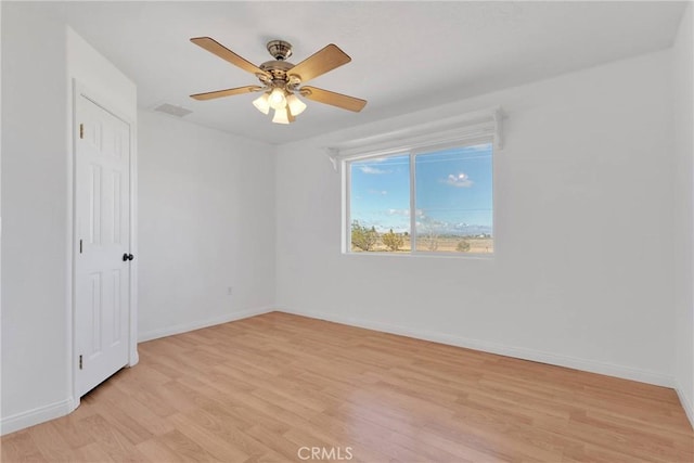 empty room with light wood finished floors, visible vents, baseboards, and a ceiling fan