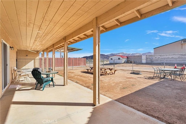 view of patio / terrace featuring a fenced backyard, a mountain view, and outdoor dining space