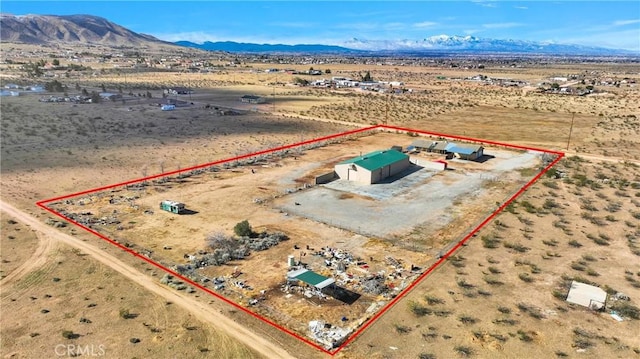 drone / aerial view featuring a rural view, a mountain view, and view of desert