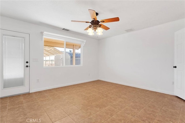 spare room with a ceiling fan, visible vents, and baseboards