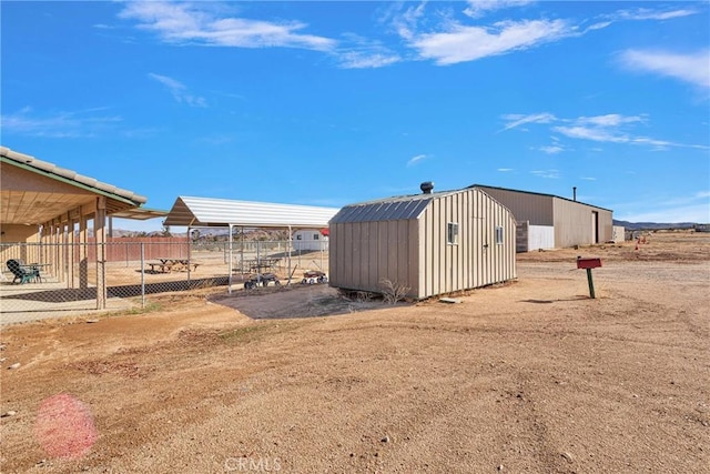 view of yard with a detached carport, fence, and an outdoor structure