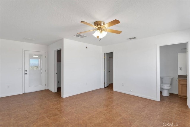 spare room featuring baseboards, a textured ceiling, visible vents, and a ceiling fan