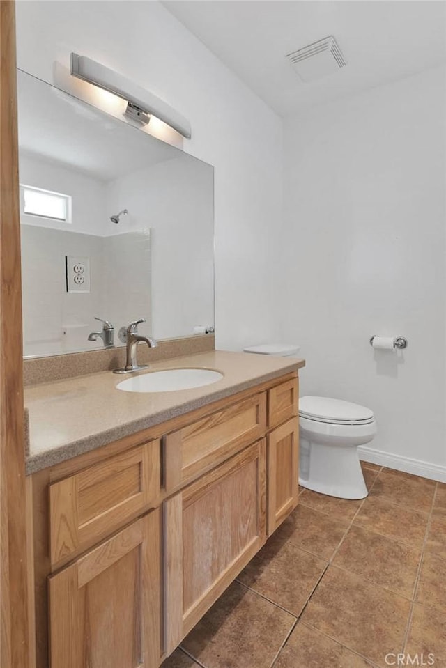 bathroom featuring visible vents, toilet, vanity, tile patterned flooring, and baseboards