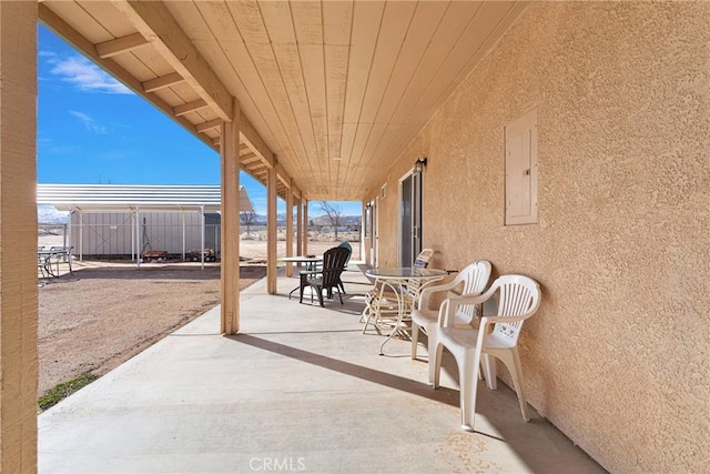 view of patio / terrace with electric panel and fence