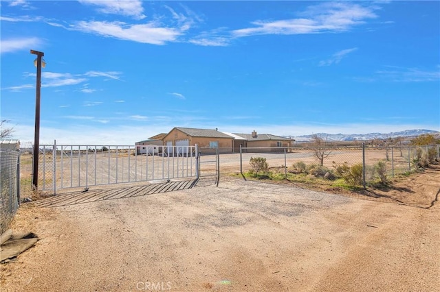 view of yard featuring a gate, fence, and a mountain view