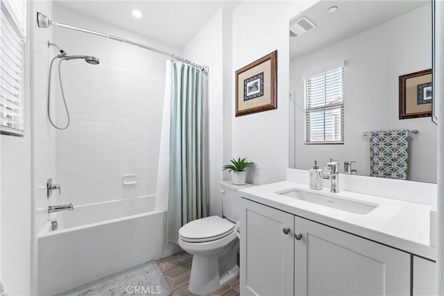 full bathroom with shower / tub combo, visible vents, vanity, and toilet