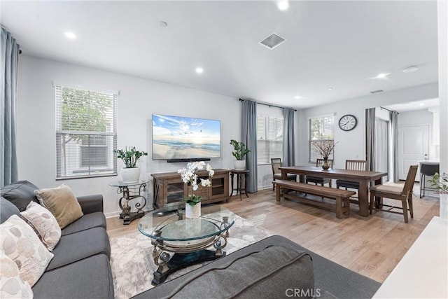 living area with light wood-style floors, baseboards, visible vents, and recessed lighting