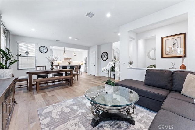 living area featuring light wood-type flooring, stairs, visible vents, and recessed lighting