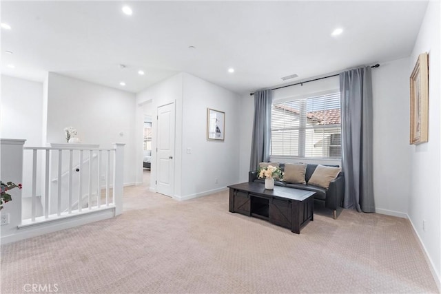 living area with light carpet, recessed lighting, baseboards, and an upstairs landing