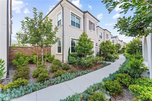 view of property exterior with fence and stucco siding