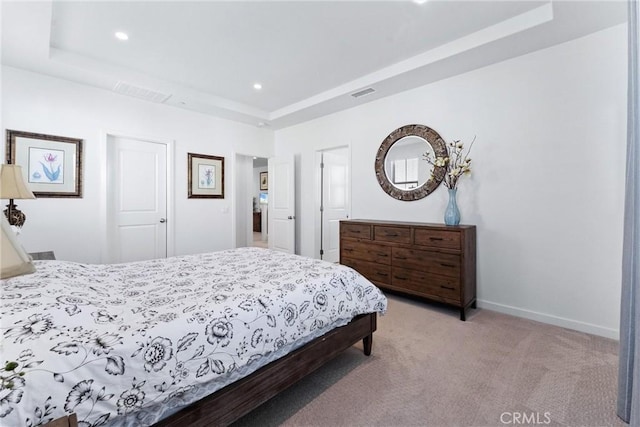 bedroom featuring a raised ceiling, visible vents, light carpet, and baseboards