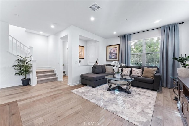 living room with recessed lighting, visible vents, baseboards, light wood-style floors, and stairway