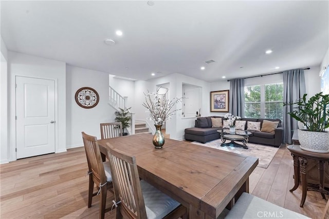 dining area with light wood-type flooring, visible vents, stairway, and recessed lighting