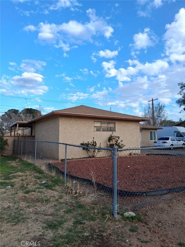 view of home's exterior featuring fence and stucco siding