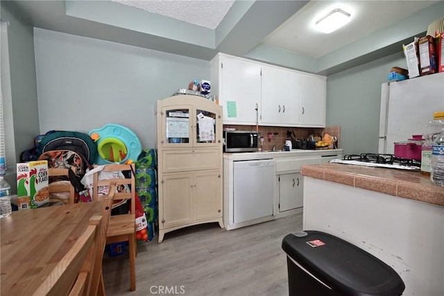 428 N Garfield Ave, Alhambra, CA 91801 - kitchen with white appliances, light wood-style flooring, white cabinetry, and tasteful backsplash