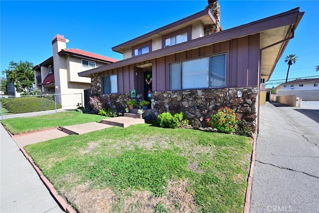 428 N Garfield Ave, Alhambra, CA 91801 - view of front facade with board and batten siding, a front yard, stone siding, and fence