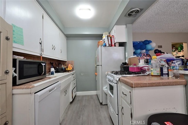 428 N Garfield Ave, Alhambra, CA 91801 - kitchen with light wood-style flooring, white appliances, visible vents, white cabinets, and backsplash