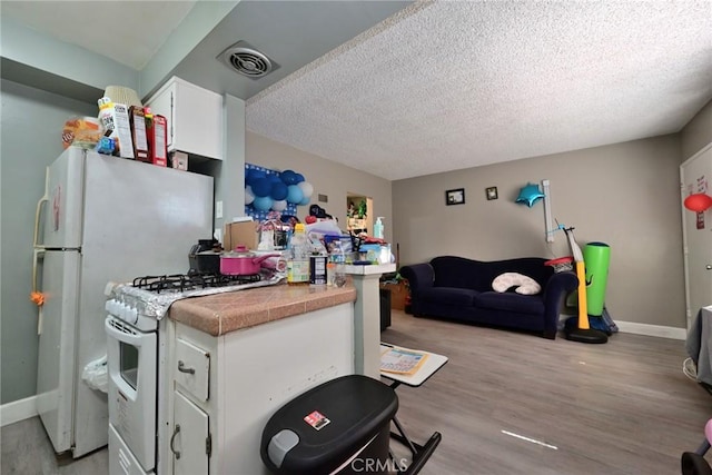 428 N Garfield Ave, Alhambra, CA 91801 - kitchen featuring light wood finished floors, white range with gas stovetop, visible vents, white cabinets, and open floor plan