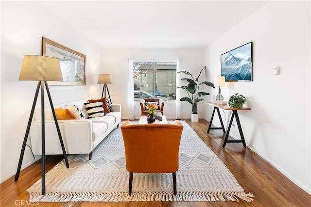 living area featuring baseboards and wood finished floors