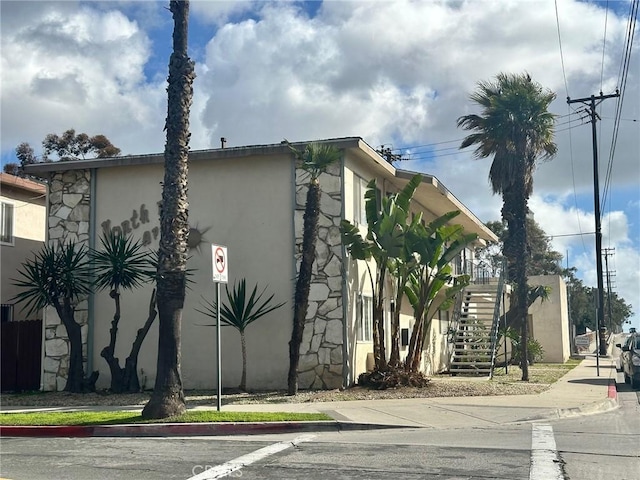 view of side of home with stairs and stucco siding