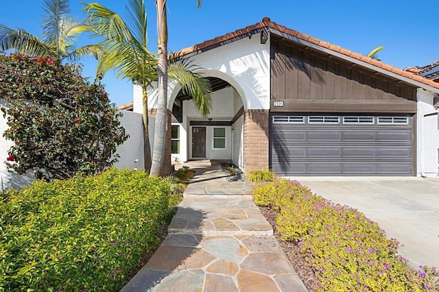 view of front of property featuring brick siding, driveway, and a garage