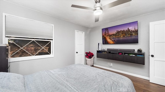 bedroom with a ceiling fan, wood finished floors, and baseboards