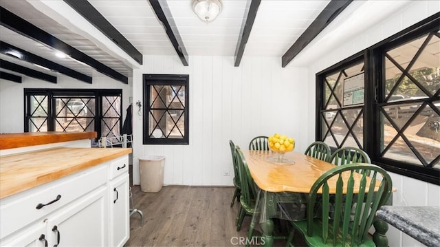 dining room with beamed ceiling and wood finished floors