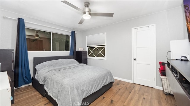 bedroom featuring wood finished floors, baseboards, and ceiling fan