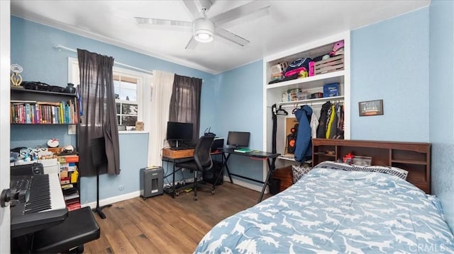 bedroom with a closet, baseboards, a ceiling fan, and wood finished floors