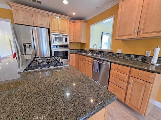 kitchen featuring a sink, stainless steel appliances, ornamental molding, and dark stone countertops