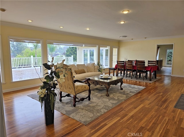 living room with recessed lighting, wood finished floors, baseboards, and ornamental molding