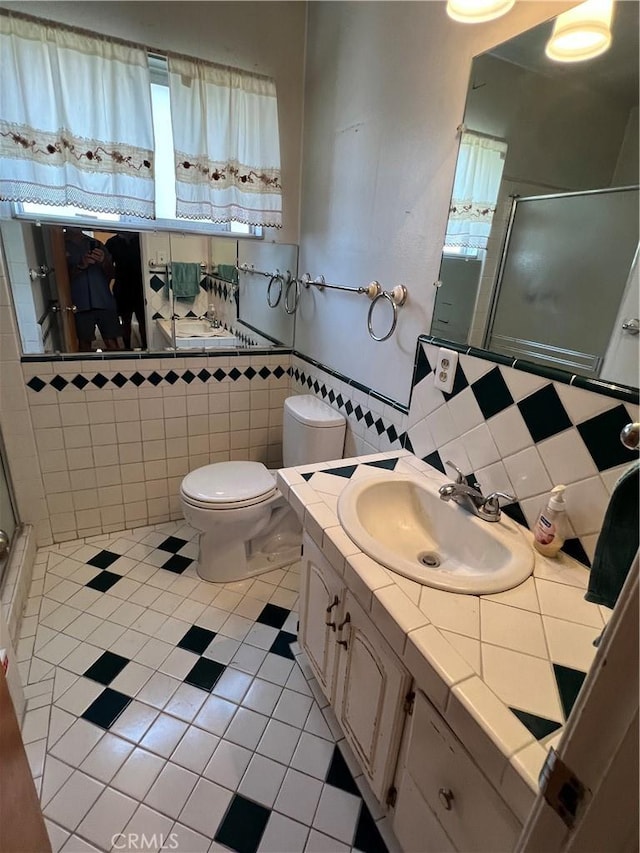 full bathroom with toilet, a stall shower, and vanity