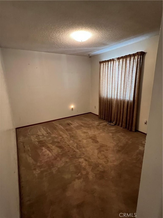 carpeted spare room with a textured ceiling