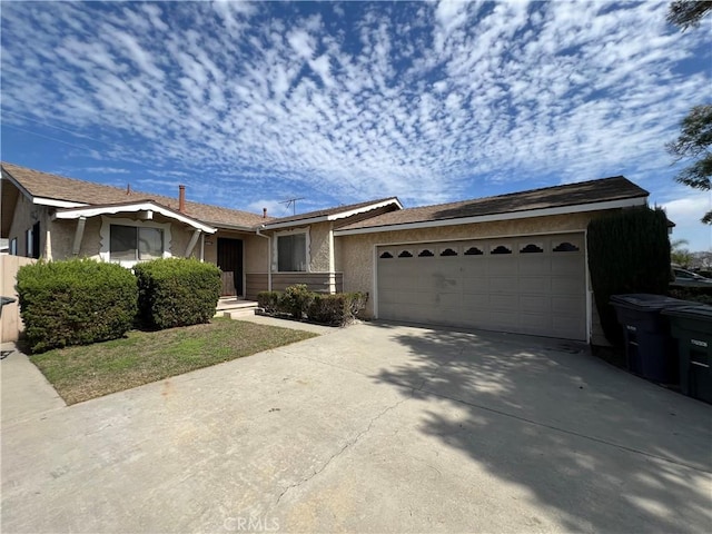 ranch-style house featuring a garage, driveway, and stucco siding