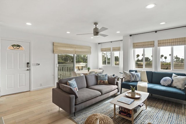 living area featuring a ceiling fan, recessed lighting, baseboards, and light wood finished floors