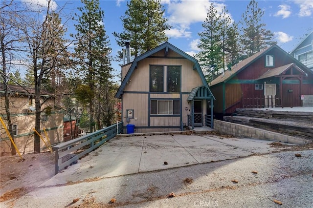 view of front of property featuring a gambrel roof and fence