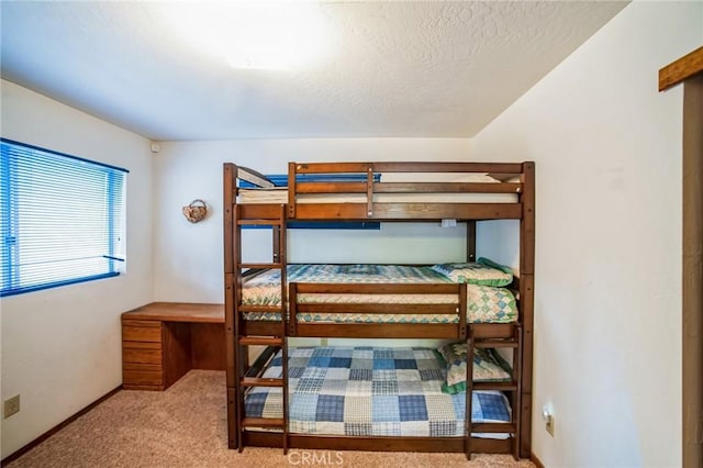 carpeted bedroom featuring baseboards and a textured ceiling