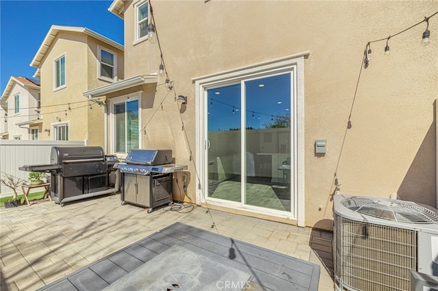 view of patio / terrace featuring fence, central AC, and grilling area