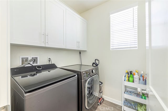 clothes washing area featuring baseboards, cabinet space, independent washer and dryer, and wood finished floors