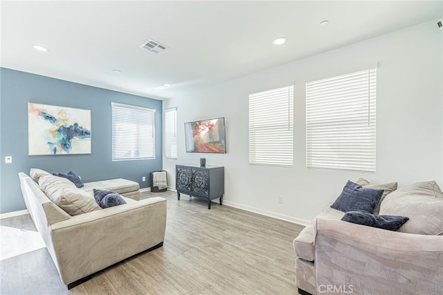 living room with recessed lighting, visible vents, baseboards, and light wood-style flooring