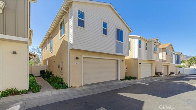 view of front facade with stucco siding, a residential view, and a garage