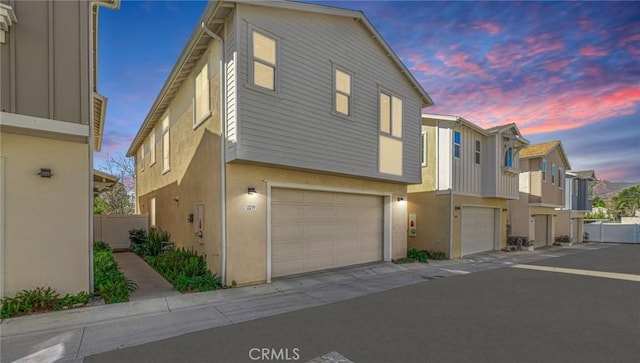 multi unit property with stucco siding and a garage