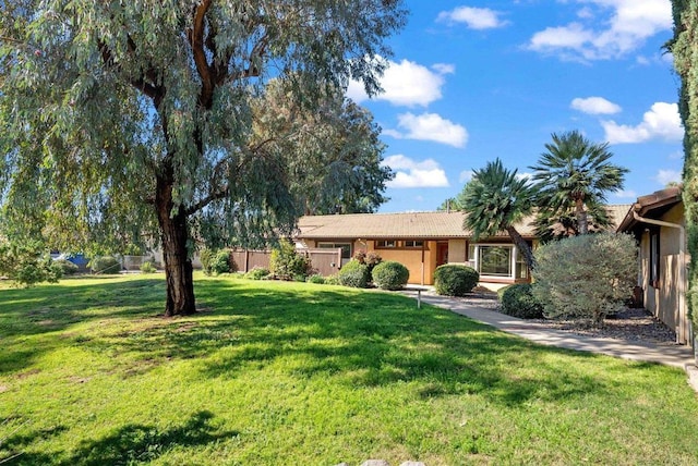 ranch-style home with stucco siding, a front yard, and fence