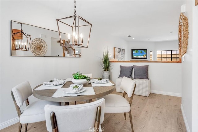 dining space featuring a chandelier, baseboards, and wood finished floors