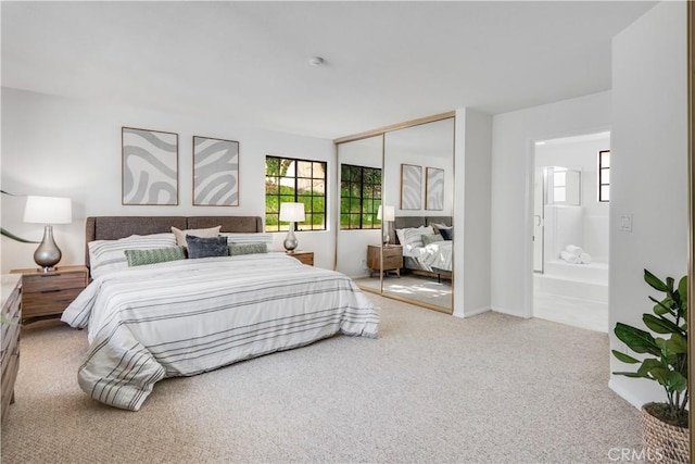 carpeted bedroom with a closet and ensuite bath