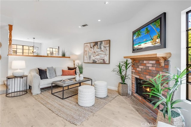 living area featuring a fireplace, visible vents, wood finished floors, and recessed lighting